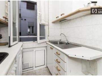 Habitación soleada con ventana con vista a la calle en...